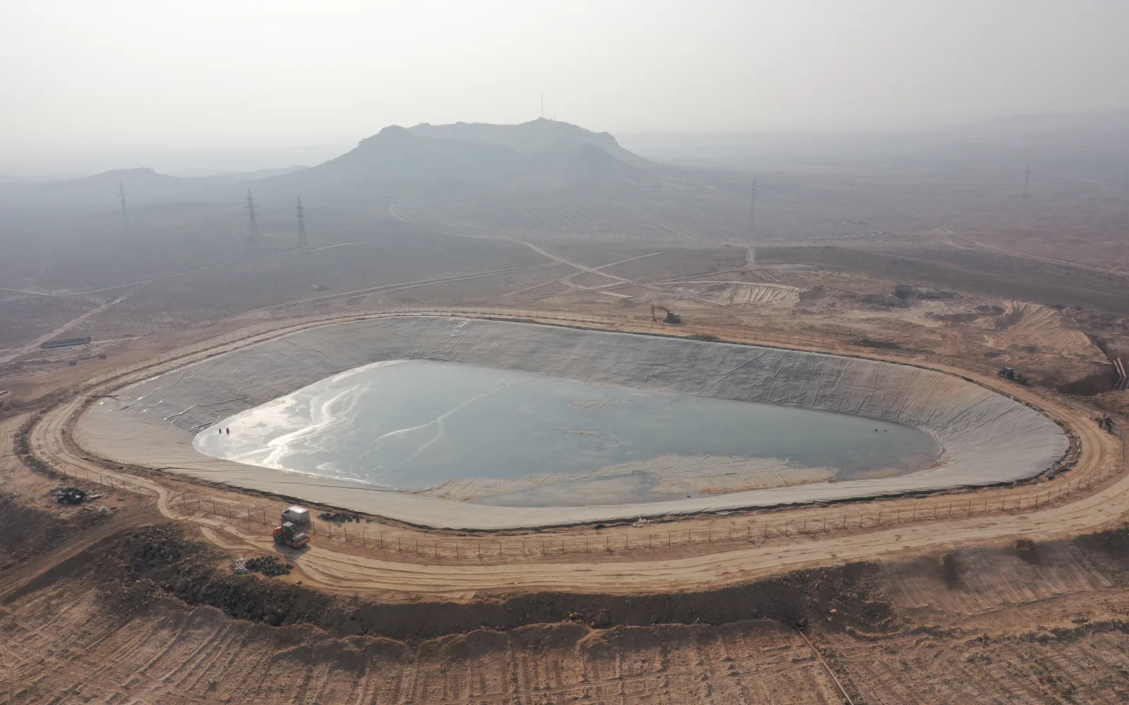 Water reservoir surrounded by rolling hills and vegetation